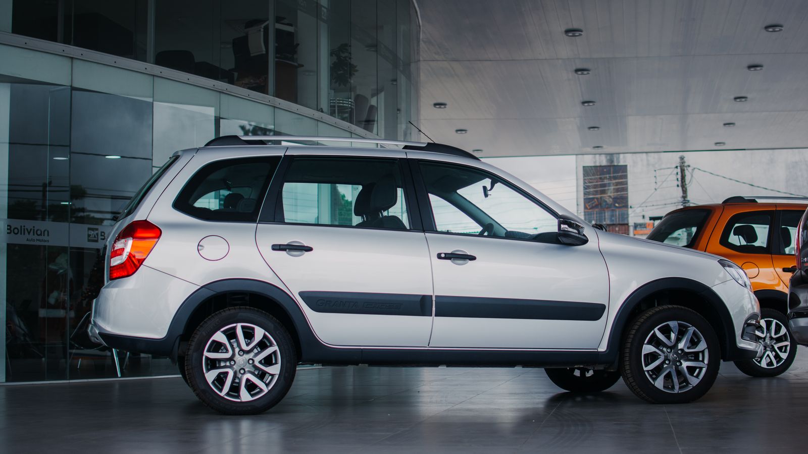 Side view of a silver Lada Granta Cross parked indoors in a Santa Cruz showroom.