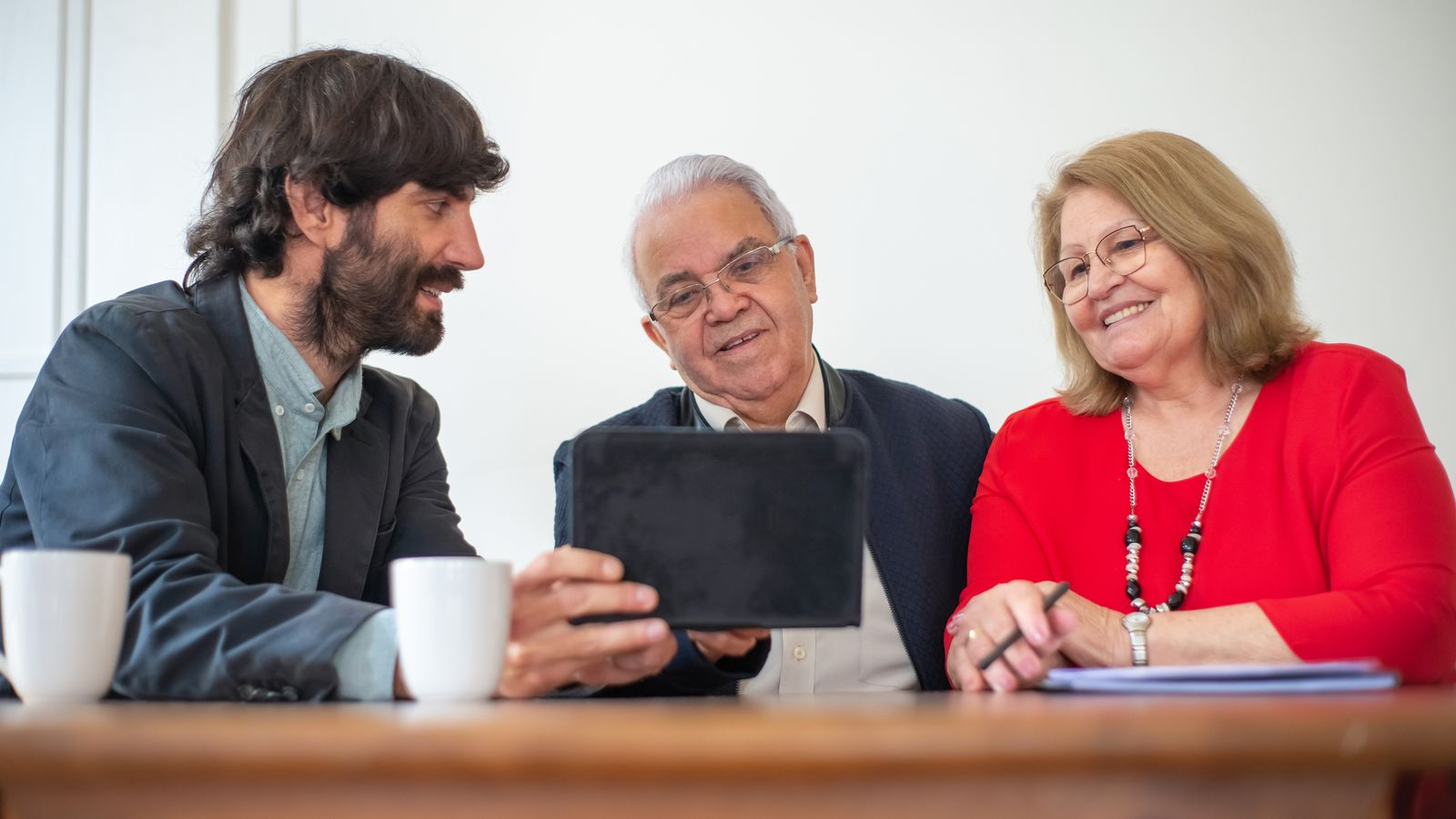 Elderly couple in a meeting with consultant, exploring financial or insurance options.